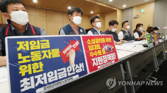 최저임금위원회 9명의 양대노총 위원들이 24일 오후 세종시 정부세종청사에서 제5차 전원회의를 앞두고 열린 2022년 적용 최저임금 노동계 최초요구 발표 기자간담회를 하고 있다. 연합뉴스